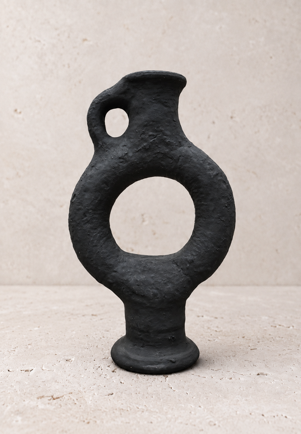 Vaas Obsidian van Casarin, matzwart ringvormig keramiek met open midden en lusvormig handvat