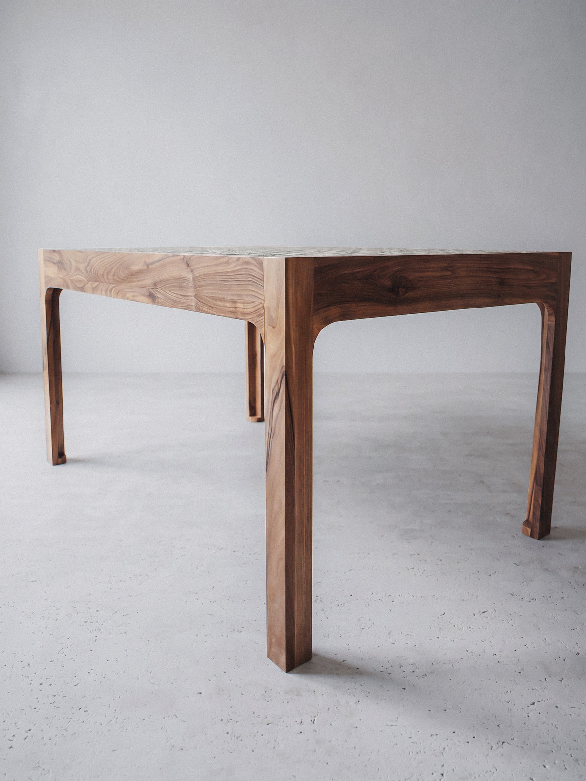 Notenhouten tafel met blad in groen Tamegrout-keramiek in een hedendaags interieur