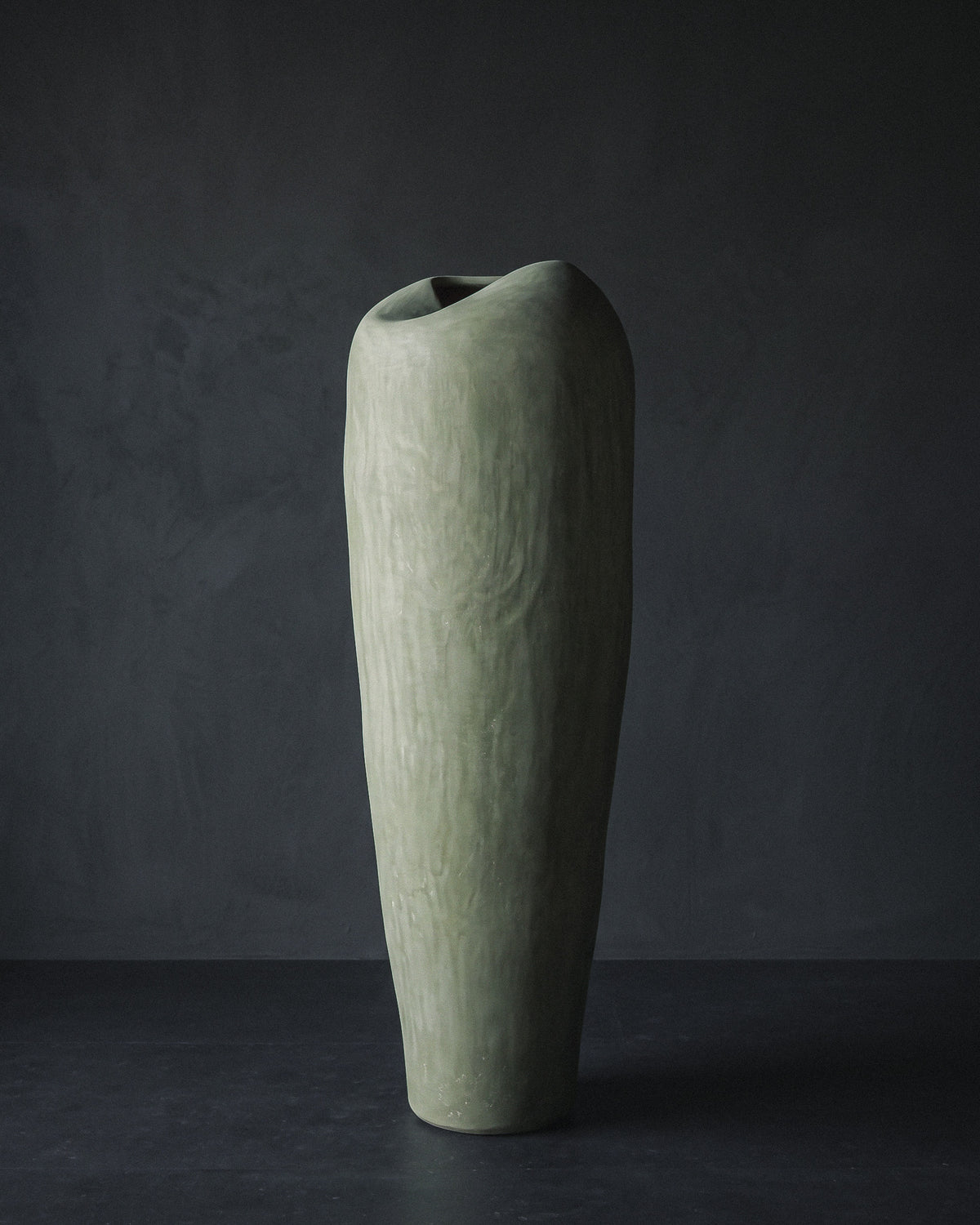 Sculptural tadelakt vessel by Casarin in muted sage, tall form with pinch-folded opening